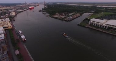 Şafak vakti Savannah Nehri 'ndeki römorkör havası şehir merkezi, liman ve Talmadge Memorial Köprüsü ile birlikte..