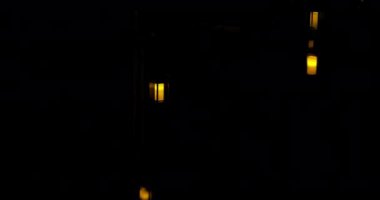 Geceleri ağaçtan sarkan mum fenerleri ve arka planda ışıldayan bir nehirden gelen su..