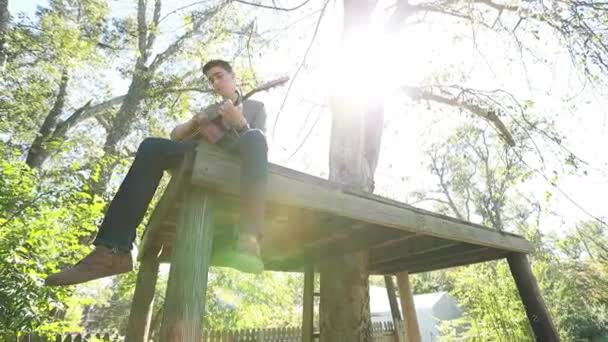 Teenage Αγόρι Παίζει Κιθάρα Μια Πλατφόρμα Δέντρο Backlight Από Φωτεινό — Αρχείο Βίντεο