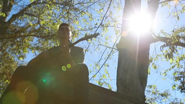 Teenage Boy Plays Guitar Tree Platform Slow Motion Silhouette Backlit — Stock Video