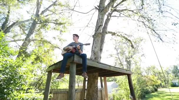 Teenage Αγόρι Παίζει Κιθάρα Μια Πλατφόρμα Δέντρο Αργή Κίνηση Πίσω — Αρχείο Βίντεο