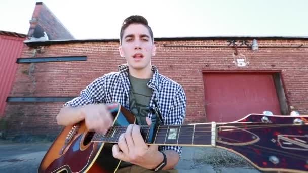 Adolescent Garçon Joue Guitare Avec Vieux Bâtiment Brique Arrière Plan — Video