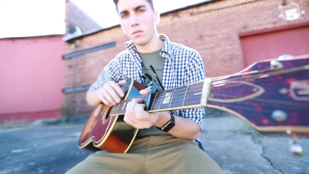 Adolescent Garçon Joue Guitare Ralenti Détail Avec Vieux Bâtiment Brique — Video