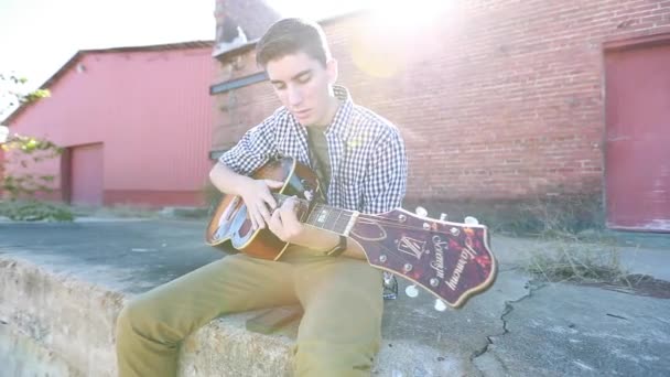 Adolescent Garçon Joue Guitare Ralenti Près Herbe Avec Vieux Bâtiment — Video