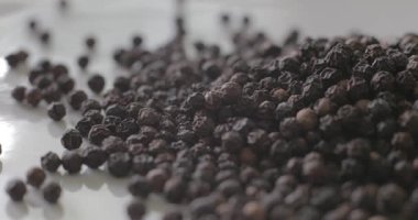 Beyaz tabakta karabiber, sağlıklı yemek pişirmek için baharat olarak kullanılmaya hazır..