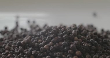 Beyaz tabakta karabiber, sağlıklı yemek pişirmek için baharat olarak kullanılmaya hazır..