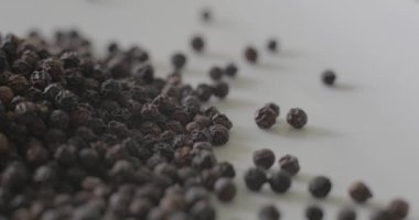 Beyaz tabakta karabiber, sağlıklı yemek pişirmek için baharat olarak kullanılmaya hazır..