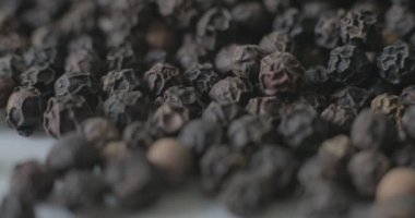 Beyaz tabakta karabiber, sağlıklı yemek pişirmek için baharat olarak kullanılmaya hazır..