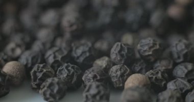 Beyaz tabakta karabiber, sağlıklı yemek pişirmek için baharat olarak kullanılmaya hazır..