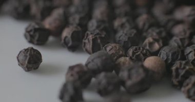 Beyaz tabakta karabiber, sağlıklı yemek pişirmek için baharat olarak kullanılmaya hazır..