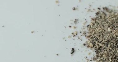 Beyaz tabakta siyah biber, sağlıklı yemek pişirmede kullanmak için..