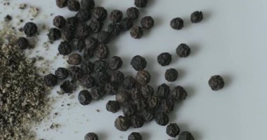 Siyah biber ve beyaz tabakta bütün biber, sağlıklı yemek pişirmede kullanmak için bir yığın içinde..