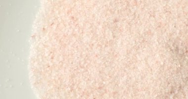 Sağlıklı bir yemek malzemesi olarak beyaz bir tabakta pembe Himalaya tuzu..