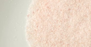Sağlıklı bir yemek malzemesi olarak beyaz bir tabakta pembe Himalaya tuzu..