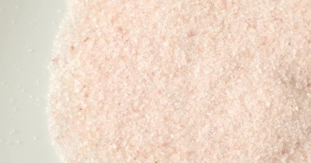 健康的な調理成分として白いプレート上のピンクヒマラヤ塩 — ストック動画