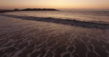 Gün doğumunda okyanus sahilinde köpüren deniz dalgaları