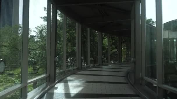 在环绕着玻璃的天桥上走过城市街道的景象 — 图库视频影像