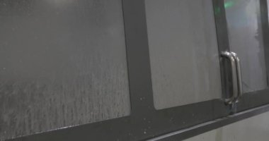 CNC üretim makinesinin camlarında köpüklü su görülüyor.