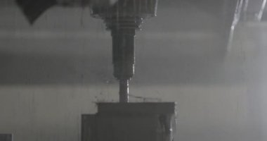 CNC makinesi bir fabrikada bir metal parçasını deliyor.