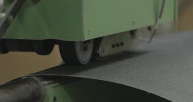 Büyük bir zımpara kağıdı fabrikada montaj bandından aşağı kayıyor.