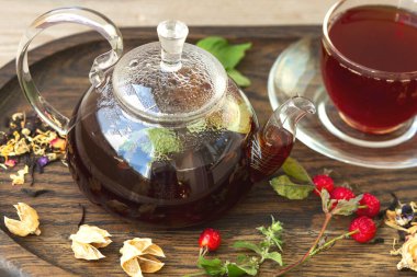 Nane, gül kalçası ve şeffaf bir kasede siyah üzümlü çay. Antioksidan, vitamin, sağlıklı yiyecekler..