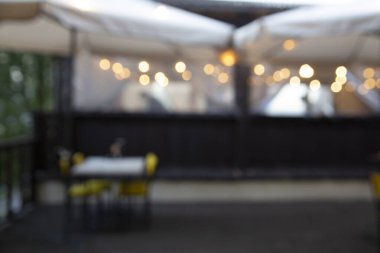 Abstract cafe with tables and blurry lights in the background.
