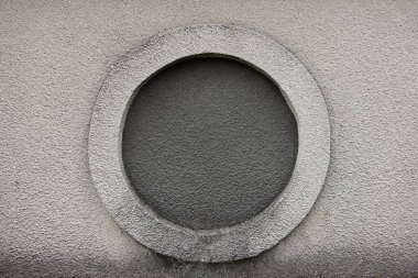 Gri alçılı taş duvar dokusu üzerinde yuvarlak pencere görüntüleme portu şablonu oluşturur