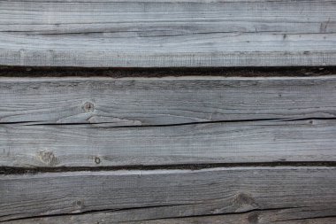 Köy arka planında yosun desenleri olan eski, yıpranmış bir ahır duvarı.