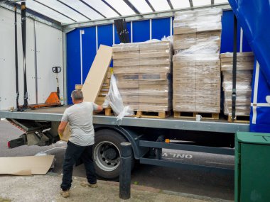 Londra mı? UK- 08.13.2021: Ağır yük araçlarından ağır paketleri boşaltan işçiler.