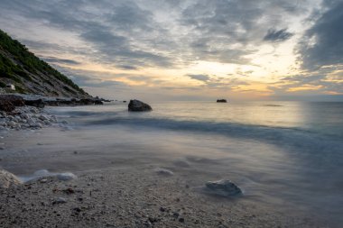 Sahilde gün batımının uzun pozu.