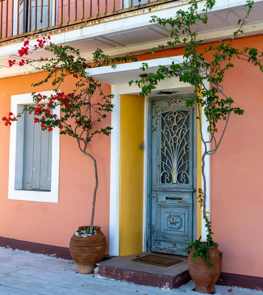 Renkli, güzel bir Yunan evi. Geleneksel kapısı, penceresi ve çiçeklerle süslenmiş..