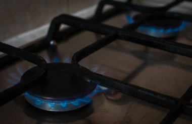 Mutfakta gaz ocağı. Mavi alevler içinde..