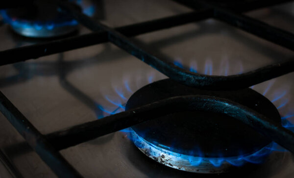 Газовая плита на кухне с голубым пламенем..