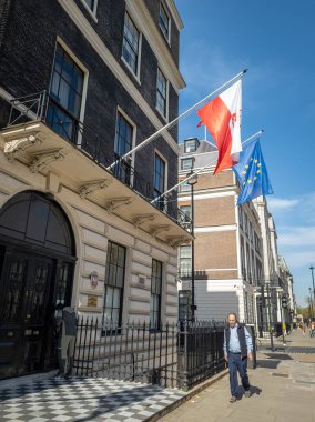 Londra mı? UK- 03.30.2021: Portland Place 'deki Polonya Cumhuriyeti Büyükelçiliği' nin sokak manzarası, binanın önünde ulusal ve Avrupa Birliği bayrakları asılı olduğunu gösteriyor.