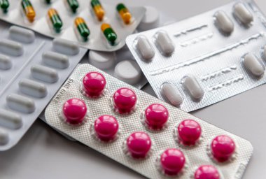 Kapsül ve tablet paketlerindeki çeşitli ilaçların yakın çekimi.