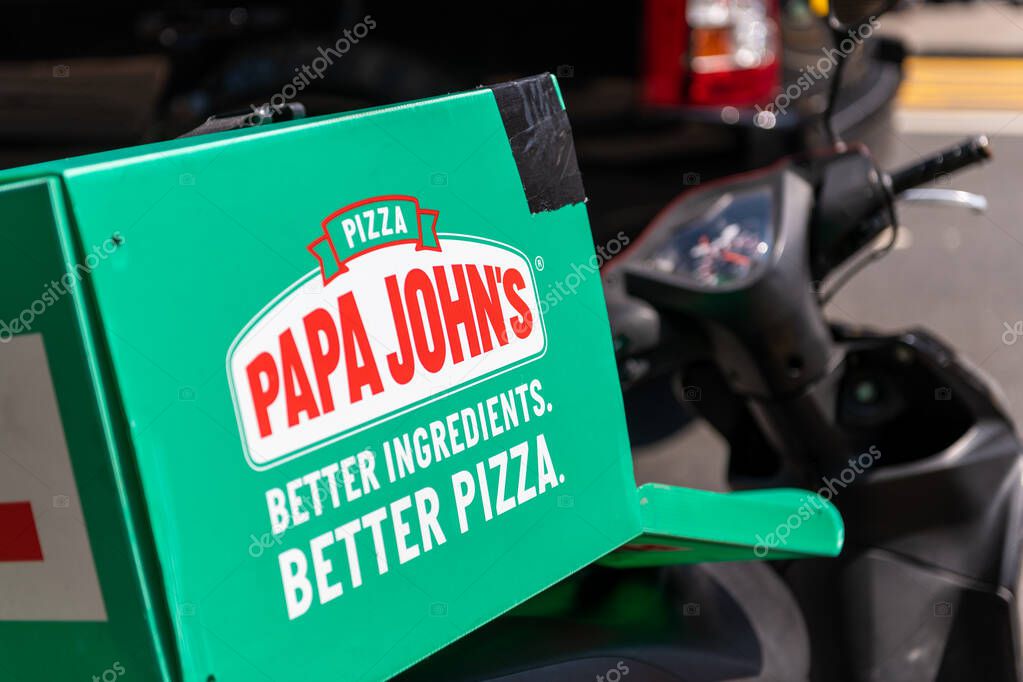London. UK- 06.26.2020: the carrier box container on the back of a motorcycle belonging to the pizza restaurant chain Papa John's which run it's own in house home delivery service.