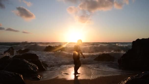 一个年富力强的人正在度假 一边在海滩上悠闲自在地散步 夕阳西下 — 图库视频影像