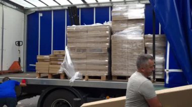 Londra mı? UK- 08.13.2021: Ağır paketler taşıyan bir nakliye kamyonunu boşaltan işçiler.