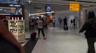 Heathrow Havaalanı. UK- 08.08. 2021: Terminal 5 'teki yolcular çıkış kapılarına doğru ilerliyorlar..