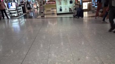 Heathrow Havaalanı. UK- 08.08. 2021: Terminal 5 'teki yolcular çıkış kapılarına doğru ilerliyorlar..