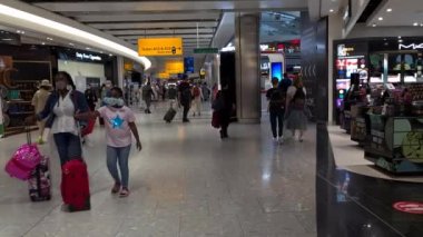 Heathrow Havaalanı. UK- 08.08. 2021: Terminal 5 'teki yolcular çıkış kapılarına doğru ilerliyorlar..
