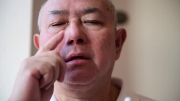 鼻水やくしゃみの症状を緩和するために鼻スプレーを適用する花粉症に苦しんで成熟した男 — ストック動画