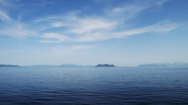 Güzel güneşli bir günde İyon Denizi sakin bir su, mavi gökyüzü ve Yunan adalarının manzarasıyla.