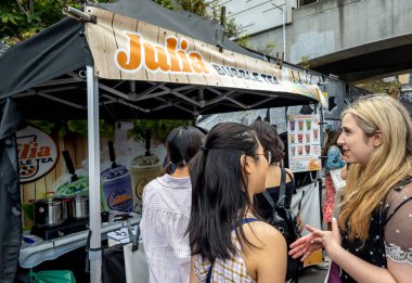 Londra mı? Birleşik Krallık-06.26.2022. Brick Lane Market 'te büyük bir turist ve ziyaretçi kalabalığı sokak yiyecek dükkanlarını ziyaret ediyor..