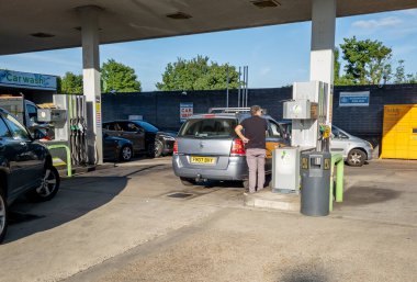 Londra mı? UK- 06.20.2022. Benzin istasyonunda çalışan bir sürücü aile arabasını tam depo fiyatıyla doldurarak tüm zamanların en yüksek benzin fiyatına ulaştı..