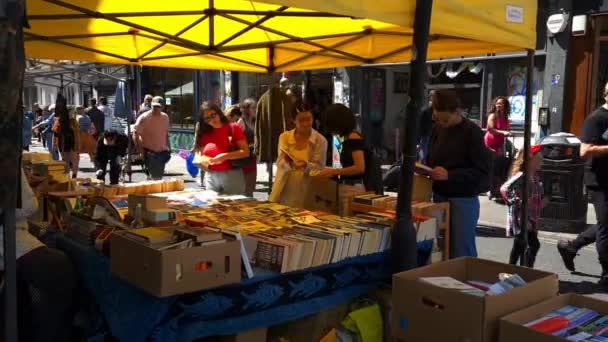 London Förenade Kungariket 2022 Turister Och Besökare Bläddrar Pappersbok Stall — Stockvideo