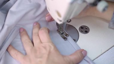 Terzi kadın çarşaf yapıyor.