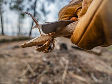 Ormanda sarı eldivenli bir bıçakla çalışmak.