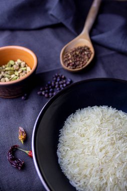 Kardamonlu pirinç kasesi, ardıç meyveli koyu mavi kumaş üzerine kırmızı biber ve sichuan kağıdı.