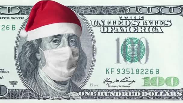 Oud biljet van honderd dollar met beschermend medisch gezichtsmasker op Benjamin Franklin met kerstmuts. Economische crisis tijdens Covid-19 Pandemisch concept. Bankbiljet van 100 dollar. 4k hoogwaardig beeldmateriaal — Stockvideo